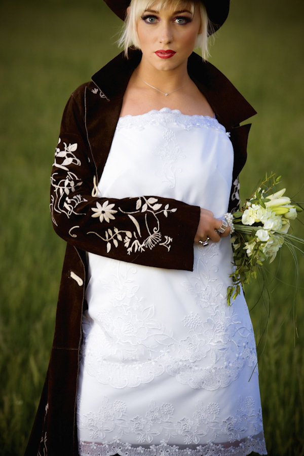 bride wearing cloak with flowery design and holding bouquet - wedding photo by top Denver based wedding photographer Hardy Klahold